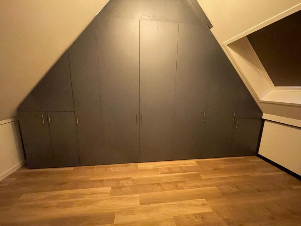 Draaideurkast tegen schuine wand met ruimte voor pijpen en wasmachine