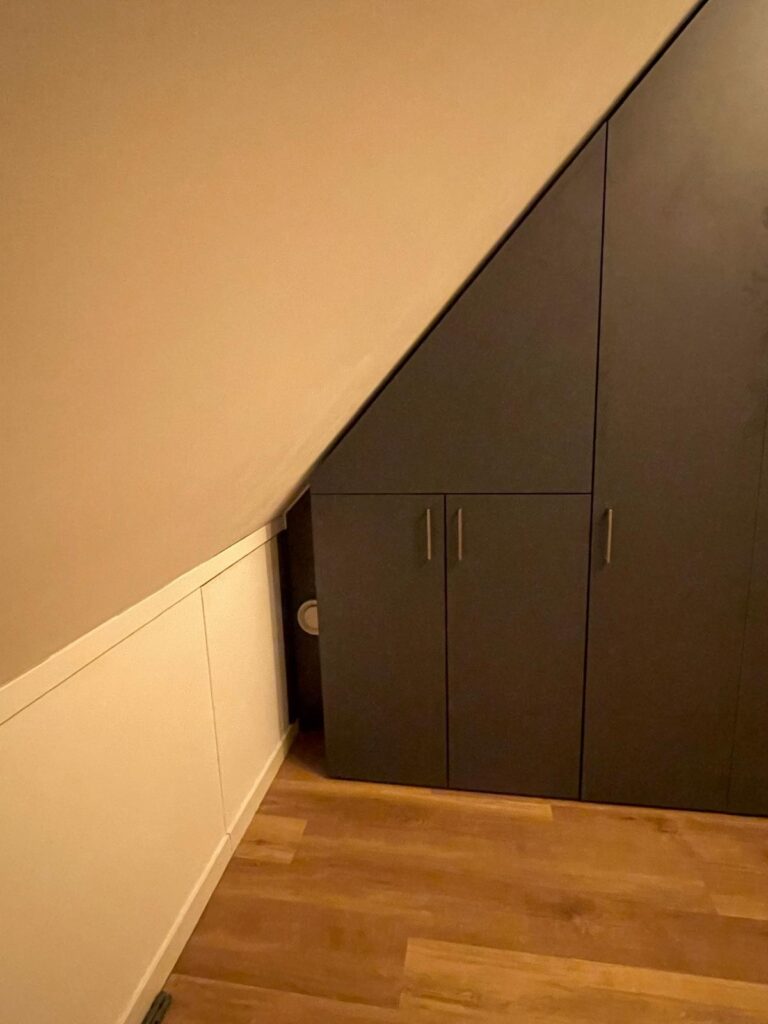 Kast tegen schuine wand met ruimte voor pijp van ketels