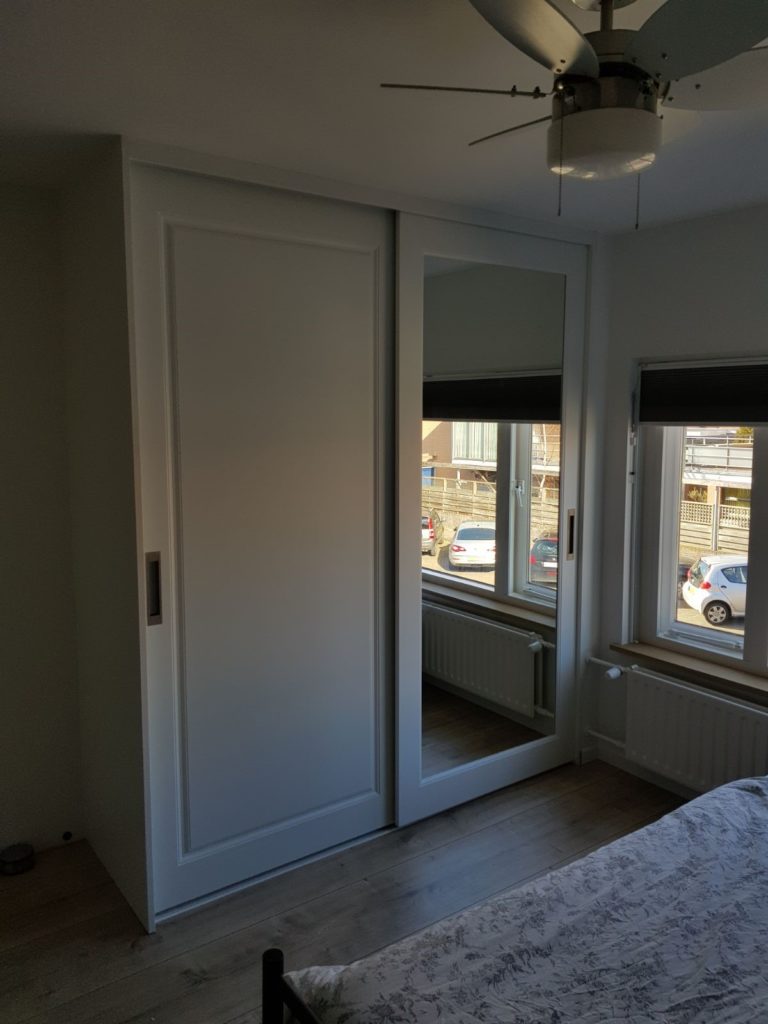 Schuifkast met klassieke deuren en een spiegeldeur